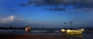 Sri Lanka, Mirissa: Touristen gehen am Strand von Mirissa, Sri Lanka, entlang.