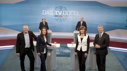 Bundeskanzlerin Angela Merkel (hinten) und der SPD-Kanzlerkandidat Peer Steinbrück (SPD) stehen am 01.09.2013 im Fernsehstudio in Berlin-Adlershof. Im Vordergrund die Moderatoren Anne Will (2.v.l) (ARD), Maybrit Illner (ZDF), Peter Kloeppel (RTL, r) und Stefan Raab (ProSieben).