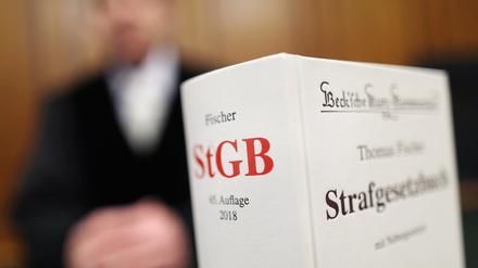 Ein Strafgesetzbuch (StGB) steht im Gericht auf der Richterbank. 