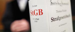Ein Strafgesetzbuch (StGB) steht im Gericht auf der Richterbank. 