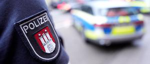 Ein Polizist steht vor einem Einsatzfahrzeug der Polizei: Am Sonnabend überprüfte die Polizei Teilnehmer einer Veranstaltung in Hamburg-Bergedorf.