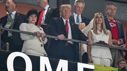 Der Präsident steht. Donald Trump schaut zu.