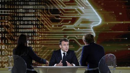 Der französische Präsident Emmanuel Macron gibt einem französischen Journalisten und einer indischen Journalistin  im Grand Palais ein Interview im Vorfeld des KI-Aktionsgipfels.