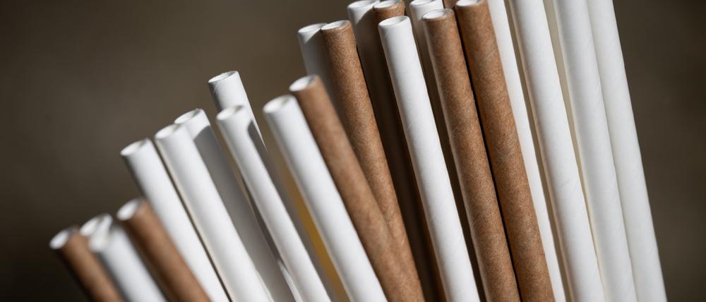 Strohhalme aus Papier stecken in einem Glas. 