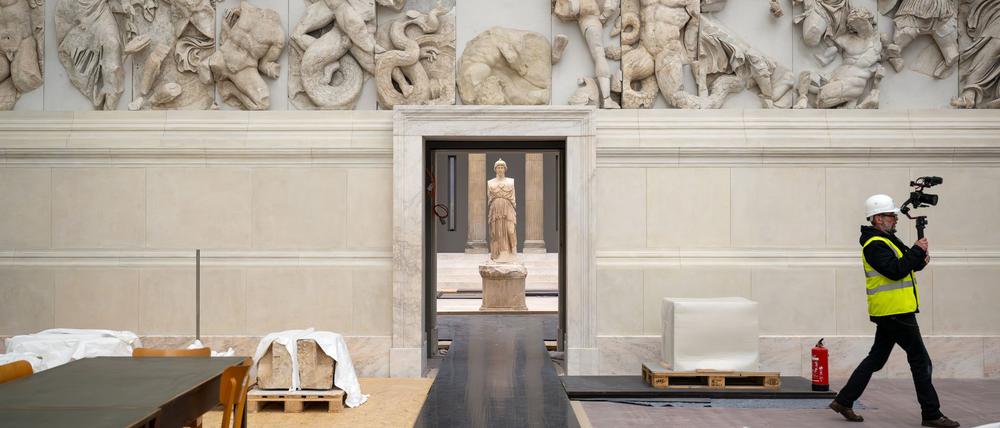 Im Hintergrund steht die Figur der Göttin Athene im Saal der Hellenistischen Architektur.