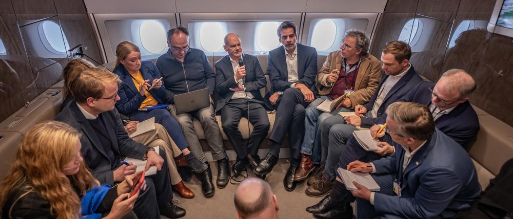 Bundeskanzler Olaf Scholz (SPD) spricht mit mitreisenden Journalisten im Besprechungsraum des A350 auf dem Flug nach Paris.