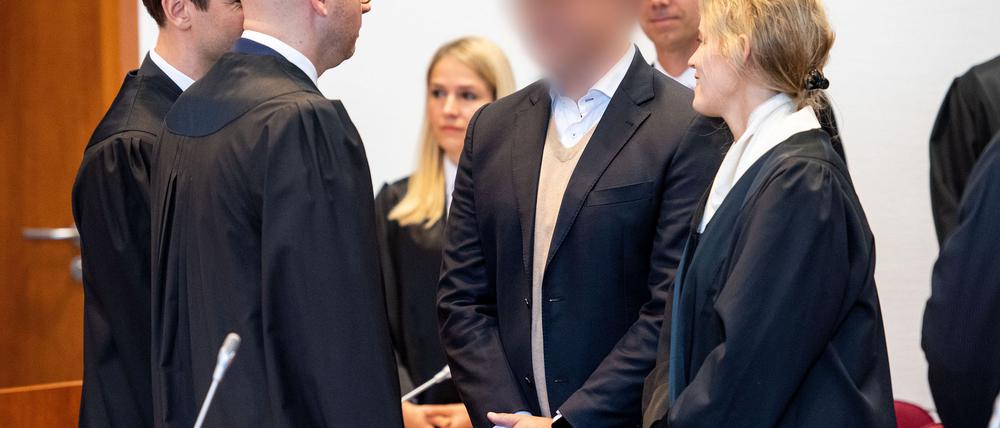 Zum Auftakt des ersten Cum-Ex-Strafprozesses 2019 vor dem Landgericht Bonn steht der Angeklagte (gepixelt) im Gerichtssaal. (Archivbild)