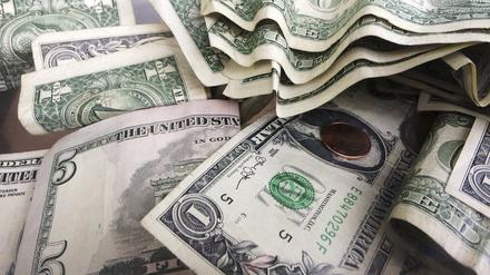Ein-Dollar- und Fünf-Dollar-Scheine liegen in einem Trinkgeldglas in einem Lokal in New York. 