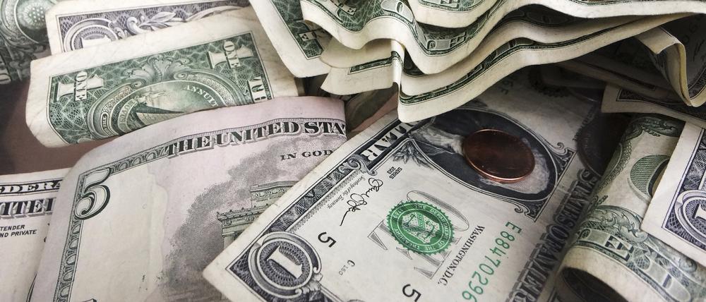 Ein-Dollar- und Fünf-Dollar-Scheine liegen in einem Trinkgeldglas in einem Lokal in New York.