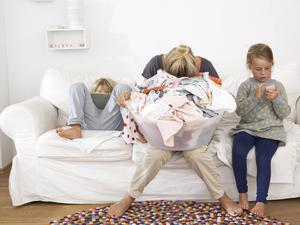 Eine erschöpfte Mutter neben ihren Kindern.