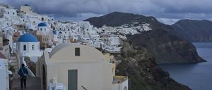  Ein Tourist nähert sich einer orthodoxen Kirche mit blauer Kuppel in Oia auf der erdbebengeschädigten Insel Santorini. 