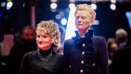 Tilda Swinton (r), Schauspielerin, und Tricia Tuttle, Intendantin der Berlinale, stehen am Eröffnungsabend der Berlinale auf dem Roten Teppich. 