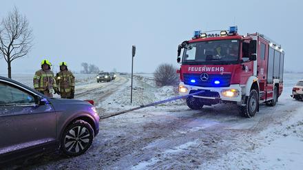 Einsatzkräfte der Feuerwehr bergen mit einem Seil ein Auto nach einem Frontalzusammenstoß im Ortsteil Klein Kreutz. 