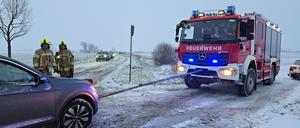 Einsatzkräfte der Feuerwehr bergen mit einem Seil ein Auto nach einem Frontalzusammenstoß im Ortsteil Klein Kreutz. 