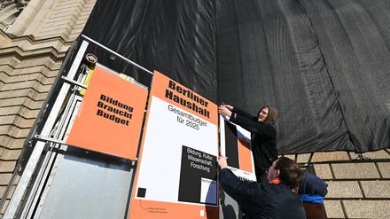 Studenten befestigen Plakate an einem Träger vor der Universität der Künste UdK, auf einem ist zu lesen „Bildung braucht Budget“. 