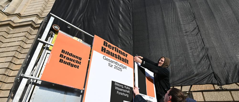 Studenten befestigen Plakate an einem Träger vor der Universität der Künste UdK, auf einem ist zu lesen „Bildung braucht Budget“. 