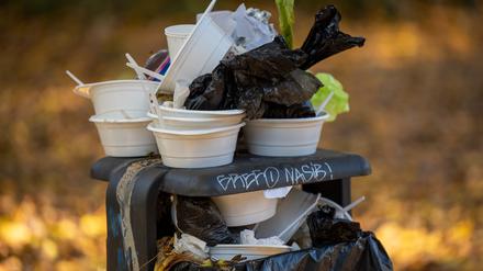 ARCHIV - 29.10.2021, Berlin: Benutze Einwegbehälter und Teller stapeln sich auf einem überfüllten Mülleimer in einem Park. (zu dpa: «Kölner Stadtrat ebnet Weg für Verpackungssteuer») Foto: Monika Skolimowska/dpa-Zentralbild/dpa +++ dpa-Bildfunk +++