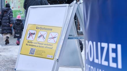 Ein Schild mit der Aufschrift ·Verbotszone· steht auf dem Leopoldplatz, während die Polizei Flyer in unterschiedlichen Sprachen verteilt und Menschen über das neue Gesetz aufklärt.  
