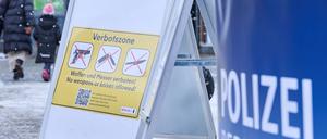 Ein Schild mit der Aufschrift ·Verbotszone· steht auf dem Leopoldplatz, während die Polizei Flyer in unterschiedlichen Sprachen verteilt und Menschen über das neue Gesetz aufklärt.  