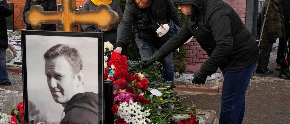 Menschen legen ein Jahr nach dem Tod des russischen Oppositionsführers Alexej Nawalny auf dem Borisowskoje-Friedhof in Moskau Blumen an seinem Grab nieder.