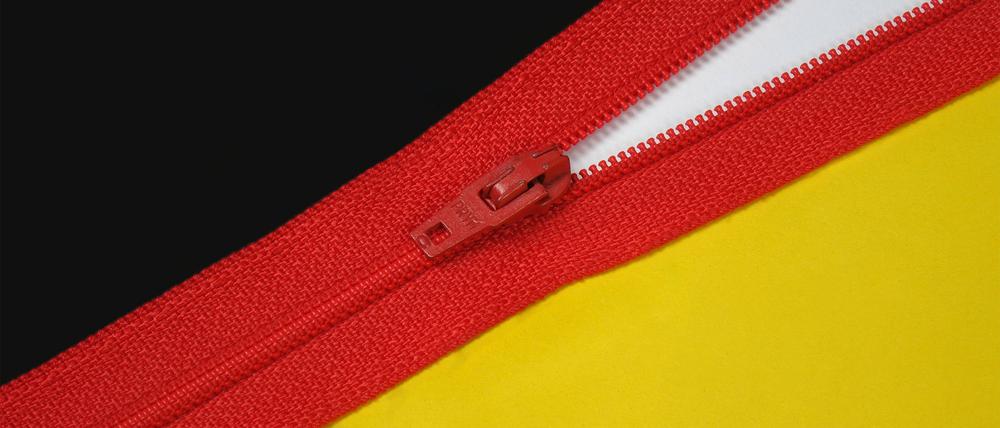 Reissverschluss mit West und Ost Reissverschluss mit West und Ost, 02.10.2023, Borkwalde, Brandenburg, Neben einem roten Reissverschluss befinden sich die Schriftzüge West und Ost. *** Zipper with West and East Zipper with West and East, 02 10 2023, Borkwalde, Brandenburg, Beside a red zipper are the writings West and East