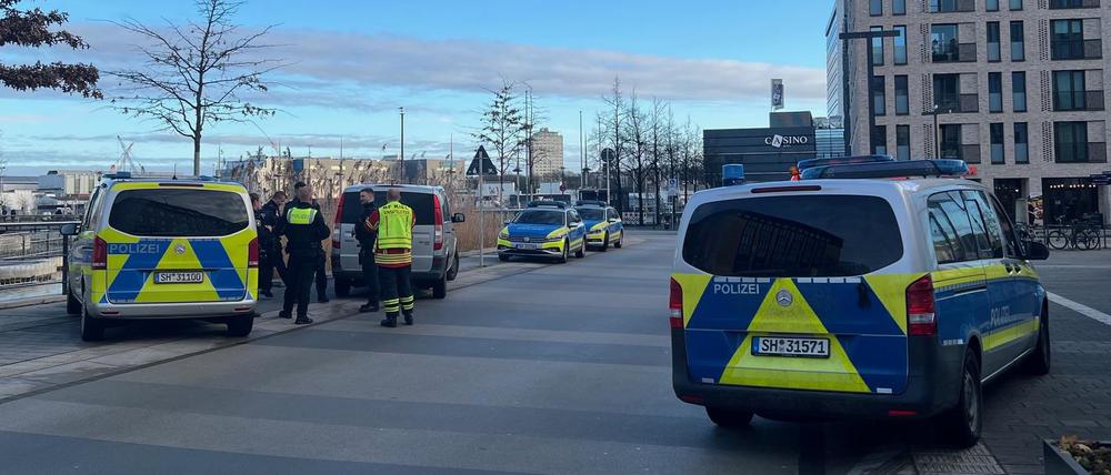 Einsatzfahrzeuge stehen am Rande der Kieler Fußgängerzone. Dort wurde zuvor ein Mensch bei einer Auseinandersetzung verletzt.