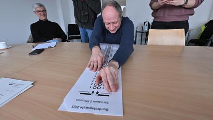 Tobias Straub vom Potsdamer Beirat für Menschen mit Behinderung zeigt die Stimmzettelschablone für blinde und sehbehinderte Wahlberechtigte.