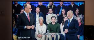 Friedrich Merz (l), Unions-Kanzlerkandidat und CDU-Bundesvorsitzender, und Bundeskanzler Olaf Scholz (SPD) sind gemeinsam auf einem Bildschirm während der Sendung ARD „Wahlarena“ zu sehen.