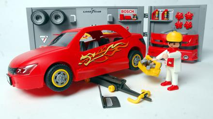 Eine Werkstatt mit Auto, Wagenheber und Mechaniker von Playmobil.