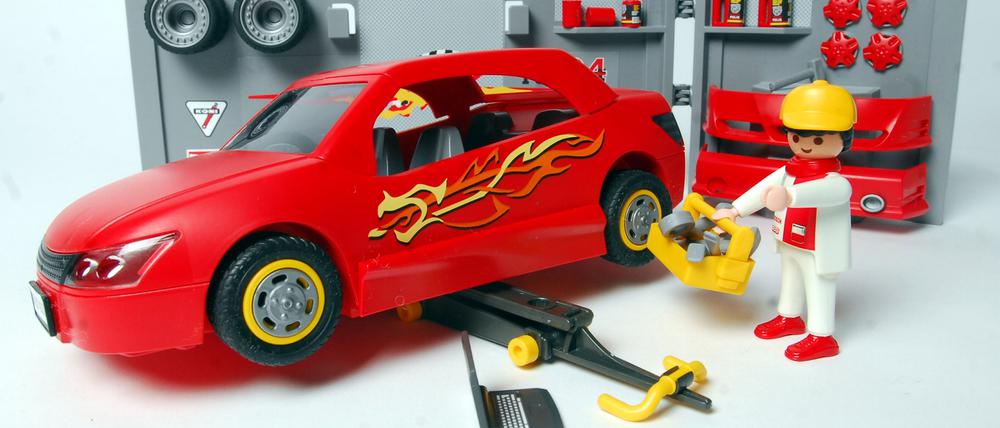 Eine Werkstatt mit Auto, Wagenheber und Mechaniker von Playmobil.
