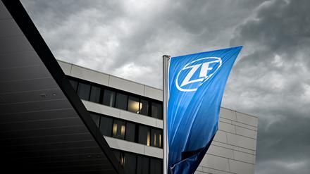 Eine Fahne mit dem Logo der ZF-Friedrichshafen AG weht vor dem ZF-Forum in Friedrichshafen, während sich im Hintergrund ein Gewitter zusammenbraut. 