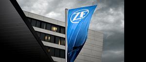 Eine Fahne mit dem Logo der ZF-Friedrichshafen AG weht vor dem ZF-Forum in Friedrichshafen, während sich im Hintergrund ein Gewitter zusammenbraut.