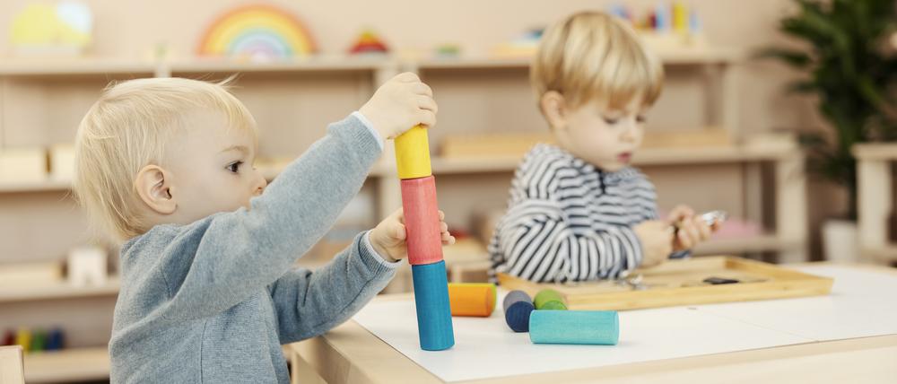 A kindergartener learning colors and shapes with montessori toy.