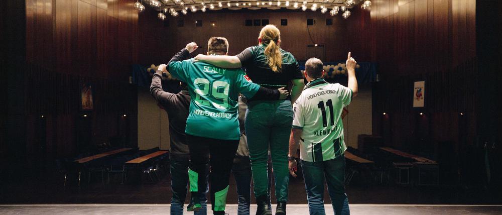 Singende Fans von Borussia Mönchengladbach in Rückansicht.