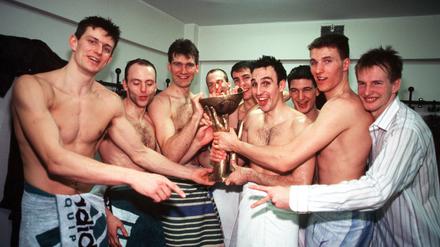 Teoman Alibegović (links, daneben Saša Obradović) feiern in der Kabine den Gewinn des Korać-Cups. 