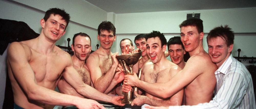 Teoman Alibegović (links, daneben Saša Obradović) feiern in der Kabine den Gewinn des Korać-Cups.