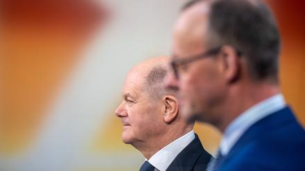 Bundeskanzler Olaf Scholz steht neben Friedrich Merz
