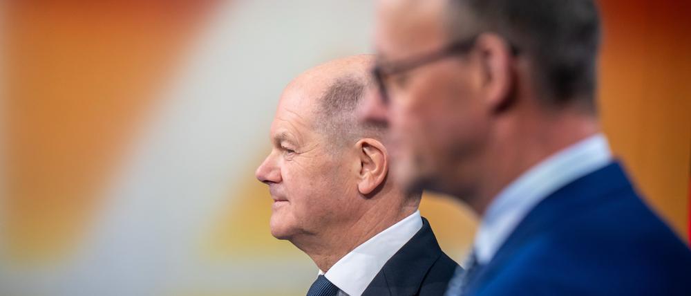 Bundeskanzler Olaf Scholz steht neben Friedrich Merz