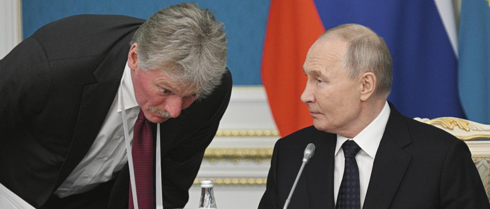 Auf diesem von der staatlichen Nachrichtenagentur Sputnik via AP veröffentlichten Foto hört Kreml-Sprecher Dmitri Peskow dem russischen Präsidenten Wladimir Putin zu.