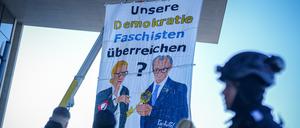 Polizeibeamte stehen am Paul-Löbe-Haus an einem Protestbanner, das gemalte Bilder von Alice Weidel, Kanzlerkandidatin der AfD, und Unions-Kanzlerkandidat Friedrich Merz zeigen soll. 