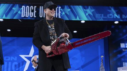  Elon Musk hält eine Kettensäge, als er bei der Conservative Political Action Conference (CPAC) im Gaylord National Resort & Convention Center ankommt. 