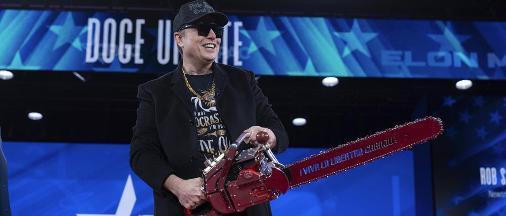 Elon Musk hält eine Kettensäge, als er bei der Conservative Political Action Conference (CPAC) im Gaylord National Resort & Convention Center ankommt. 