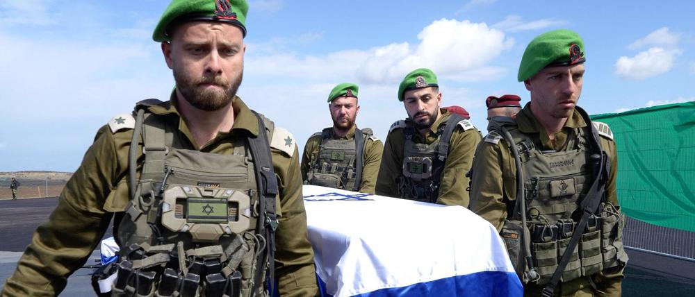 IDF-Offiziere der israelischen Armee tragen im Gazastreifen einen der vier Särge, bedeckt mit der israelischen Flagge, die sie vom Internationalen Roten Kreuz erhalten haben, nachdem sie zuvor von der Terrororganisation Hamas in Chan Junis im Gazastreifen an das IKRK übergeben worden sind. 
