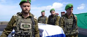 IDF-Offiziere der israelischen Armee tragen im Gazastreifen einen der vier Särge, bedeckt mit der israelischen Flagge, die sie vom Internationalen Roten Kreuz erhalten haben, nachdem sie zuvor von der Terrororganisation Hamas in Chan Junis im Gazastreifen an das IKRK übergeben worden sind. 