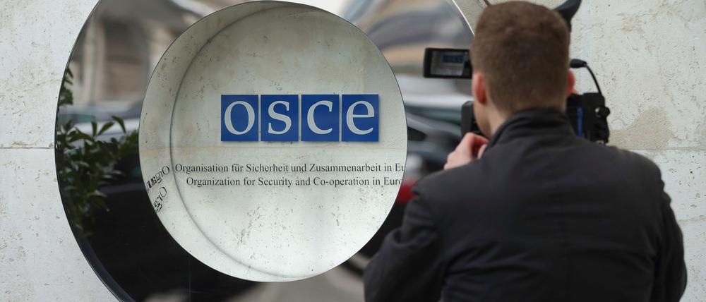 Ein Kameramann filmt das Logo der OSZE, die Beobachter zur Bundestagswahl schicken will. (Archivbild)