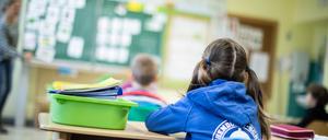 Kinder sitzen in einer Grundschule (Symbolfoto).