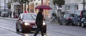 Ein älterer Mann überquert eine Straße in Berlin-Prenzlauer Berg.