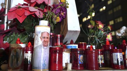 Kerzen stehen am Fuß einer Marmorstatue des verstorbenen Papstes Johannes Paul II. vor der Poliklinik Agostino Gemelli, wo Papst Franziskus wegen einer Lungenentzündung behandelt wird.