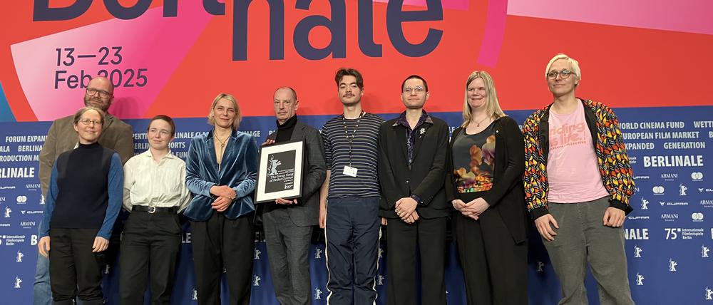 Die Tagesspiegel-Leserjury 2025 vergibt ihren Preis, den Ko-Produzent Marc-Daniel Dinand (M)  engegennimmt. (v.l.: Christian Riegel, ebenfalls Ko-Produzent, Amari Barash, Manuela Ziegler, Akito Ruhl, Max Simbolon, Katja Horstmann, Julian Gabrysch. 