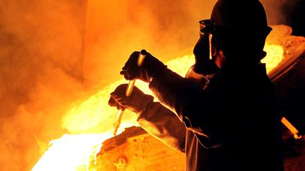 Ein Arbeiter ist in einem Stahlwerk zu sehen.